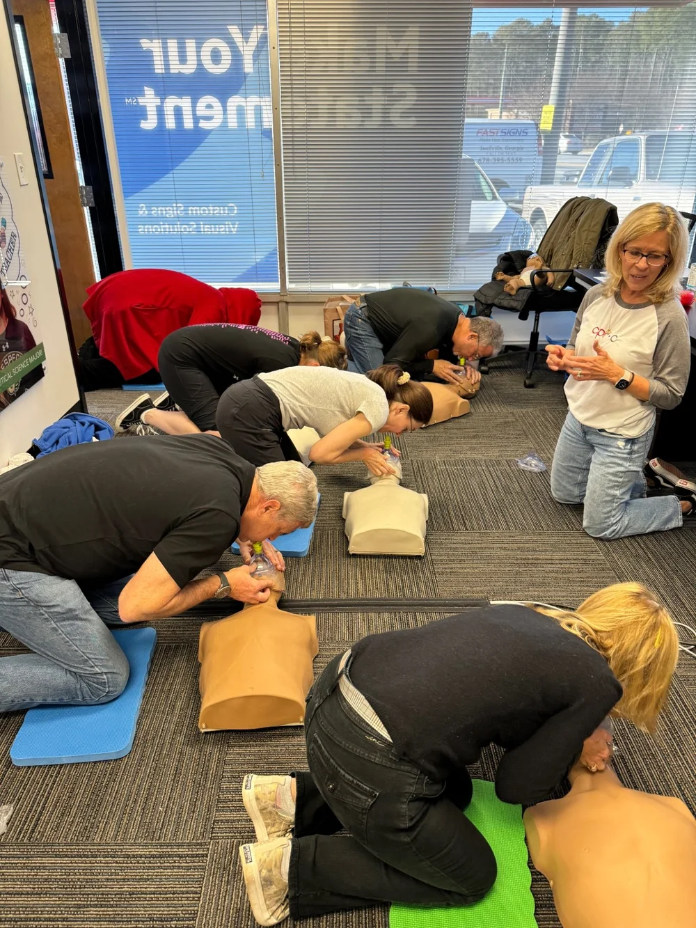 An instructor overseeing CPR practice on manikins